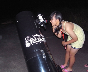天体望遠鏡を笑顔で覗く少女