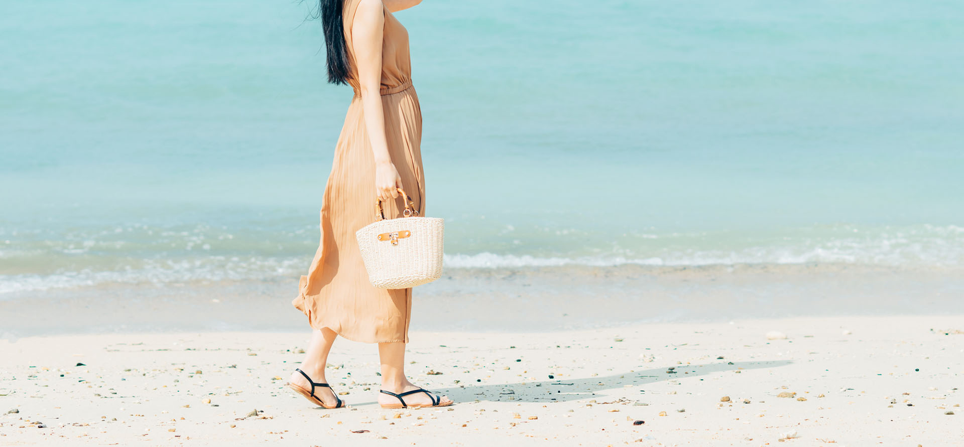 浜辺を歩くワンピースを着た女性